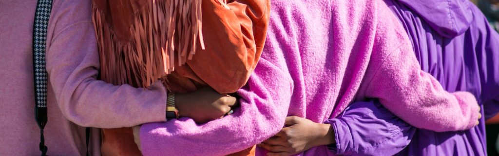 four women embracing showing the trait of caring for one another